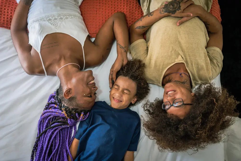 Family laying on bed and smiling